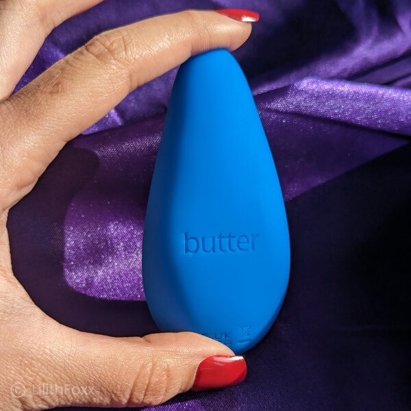 An image of Lilithfoxx holding the personal massager men's prostate orgasm toy from Butter Wellness. Top view.