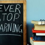 A chalkboard sign that says never stop learning.