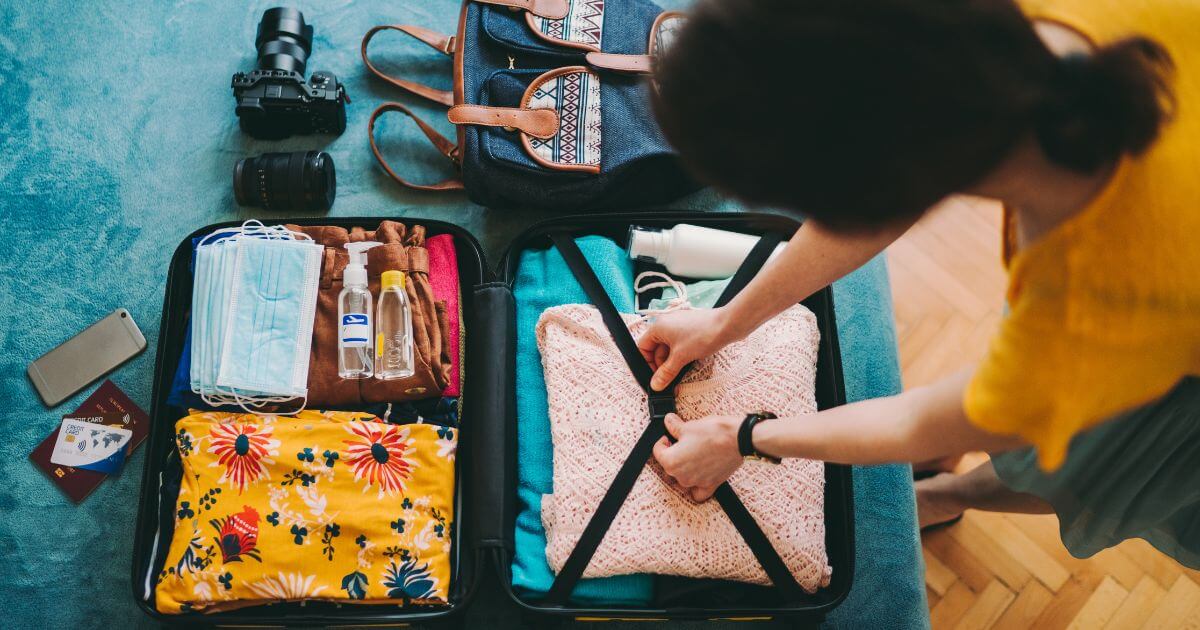 Person packing comfort and care items into a suitcase, representing a BDSM aftercare kit for post-scene recovery, sensory support, and practical aftercare.