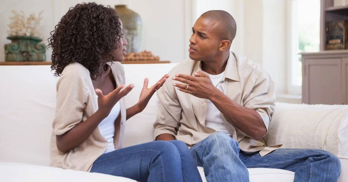 Couple having a serious conversation at home, representing how to tell your partner you're kinky and discuss BDSM interests openly.